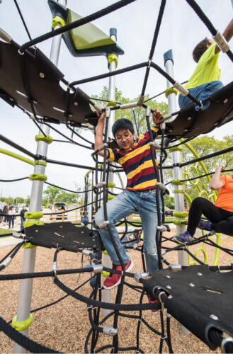 boy climbing netted play equipment
