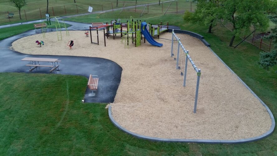 Swing set and play structures at Andrew Mynarski VC Park.