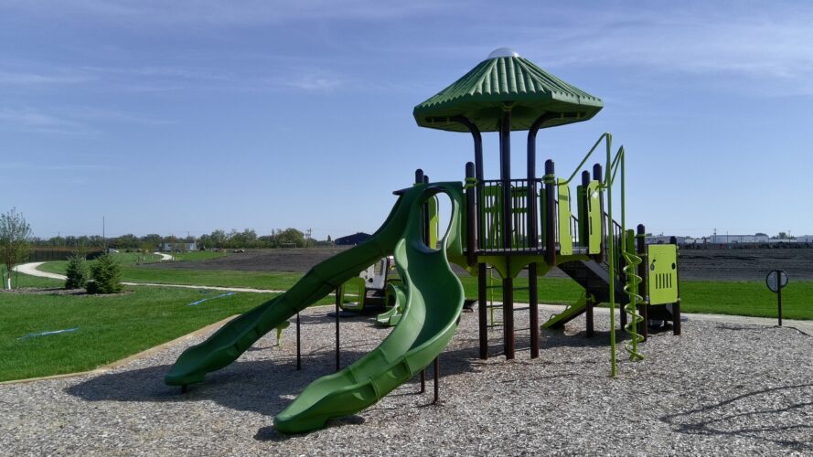 Large green play structure at Forest Grove Playground.