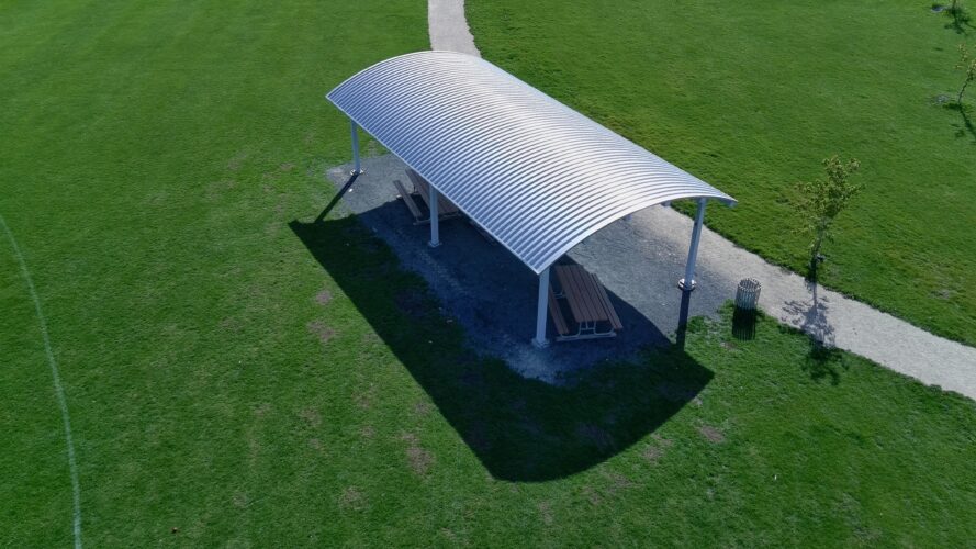 Silver commercial outdoor shelter positioned next to the path for the cricket field.